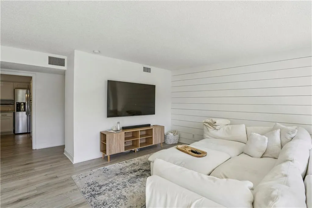Living area featuring wood finished floors and a textured ceiling