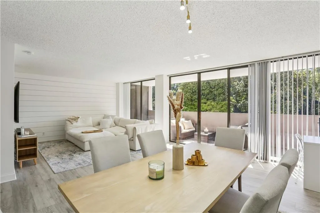 Dining room featuring floor to ceiling windows, healthy amount of natural light, a textured ceiling, and light wood-style floors