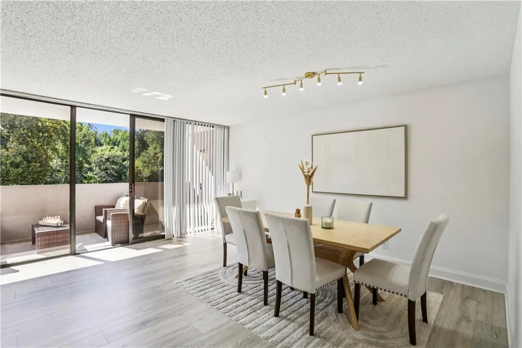 Dining room with expansive windows, light wood-style floors, a textured ceiling, and rail lighting