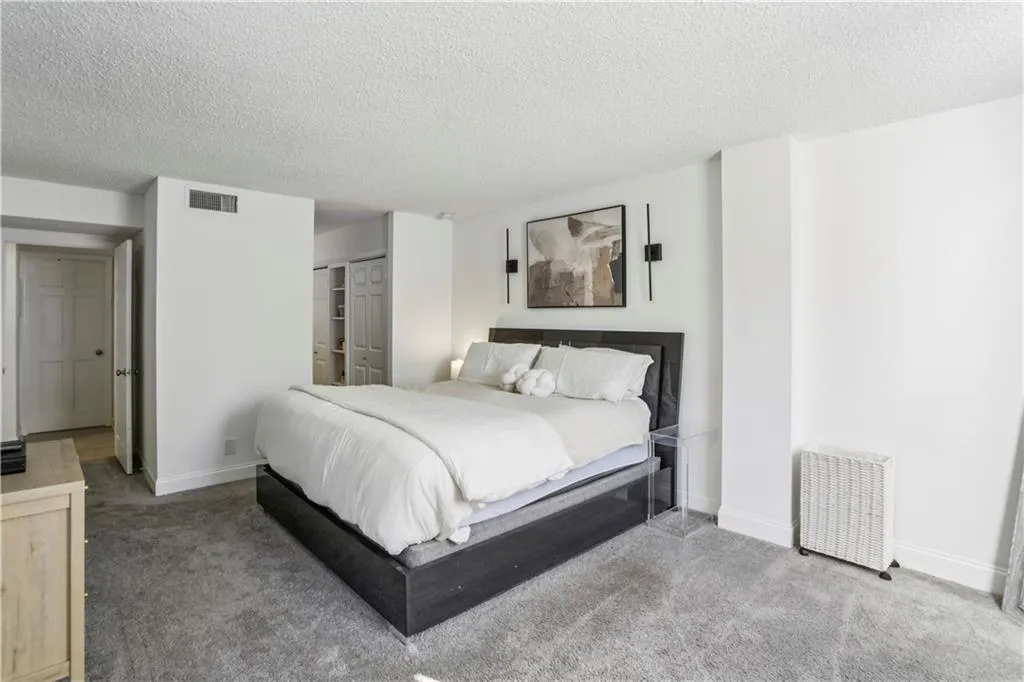 Bedroom featuring carpet flooring, a textured ceiling, a closet, and radiator