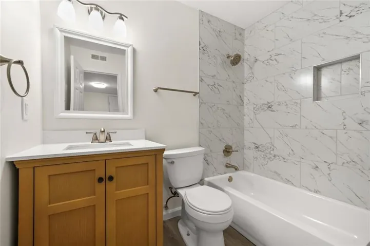Wood-finish vanity with a white countertop and undermount sink