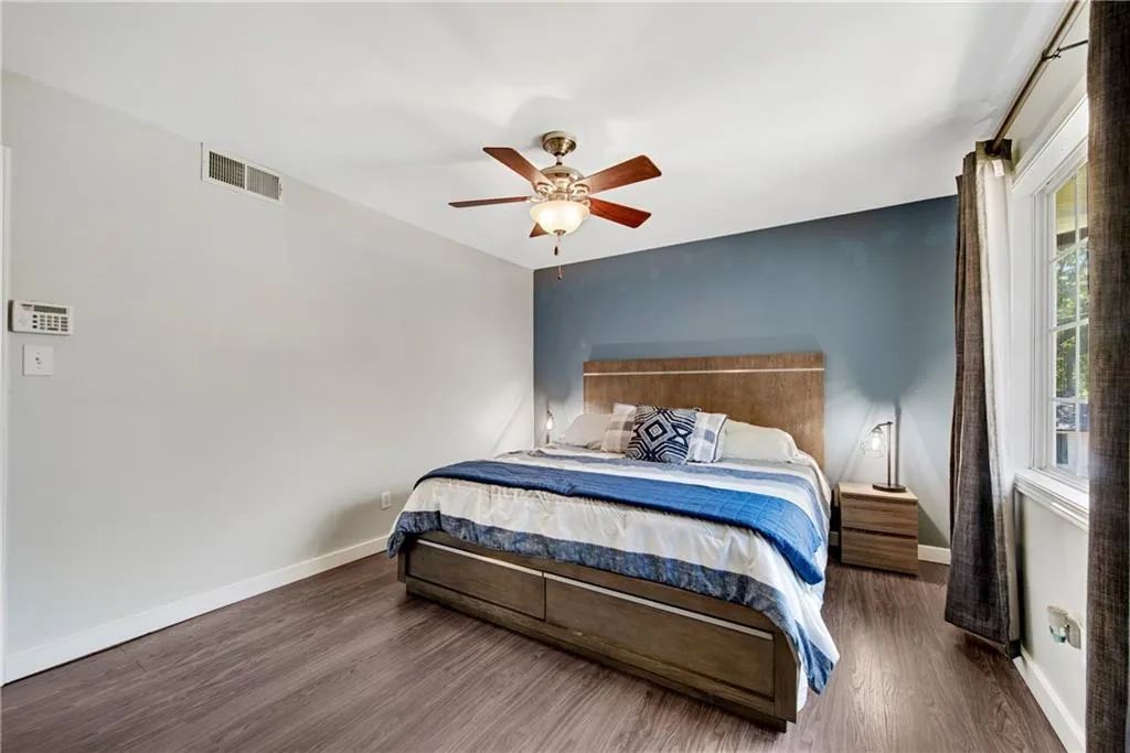 Bedroom with ceiling fan and dark hardwood / wood-style flooring
