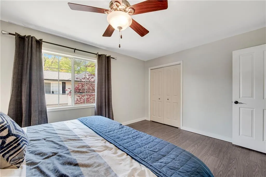 Bedroom with a closet, dark wood-type flooring, and ceiling fan