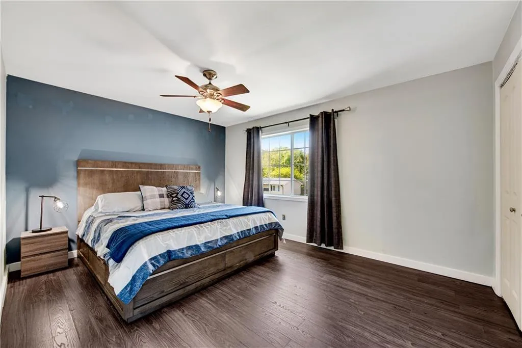 Bedroom with a closet, ceiling fan, and dark hardwood / wood-style floors