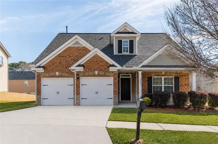 Brick exterior with gabled roof lines, two-car garage, and a covered entry