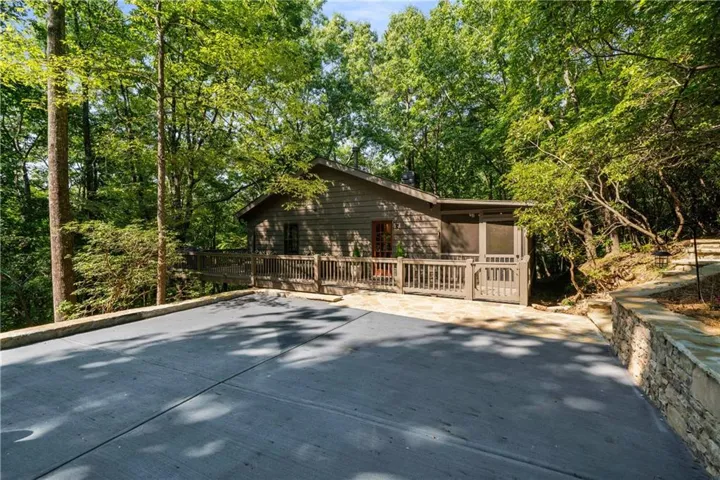 Front of 62 Crazy Bear Ridge highlighting the expansive driveway that holds four large sized cars. A rare parking opportunity in Big Canoe!