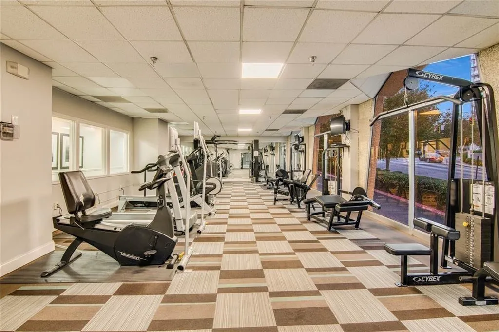 Gym with light colored carpet and a drop ceiling