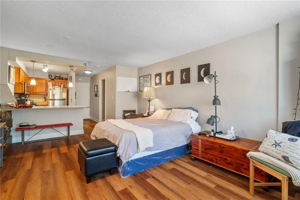 Bedroom with hardwood / wood-style flooring and a textured ceiling