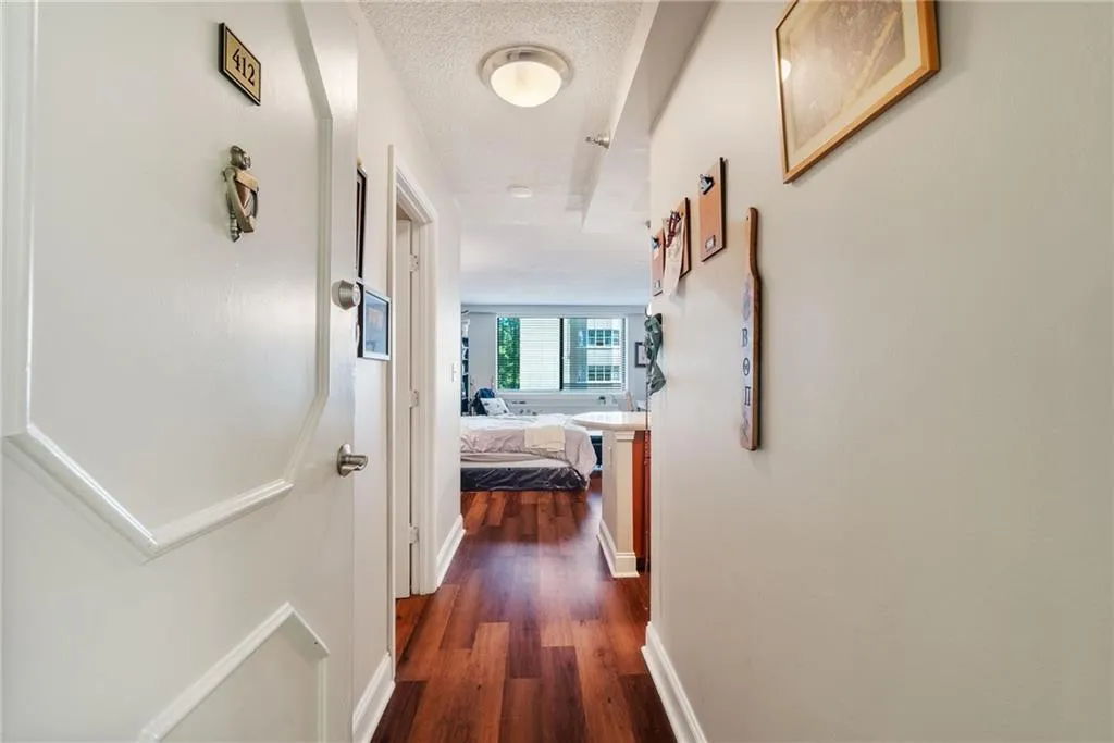 Hall featuring a textured ceiling and dark hardwood / wood-style flooring
