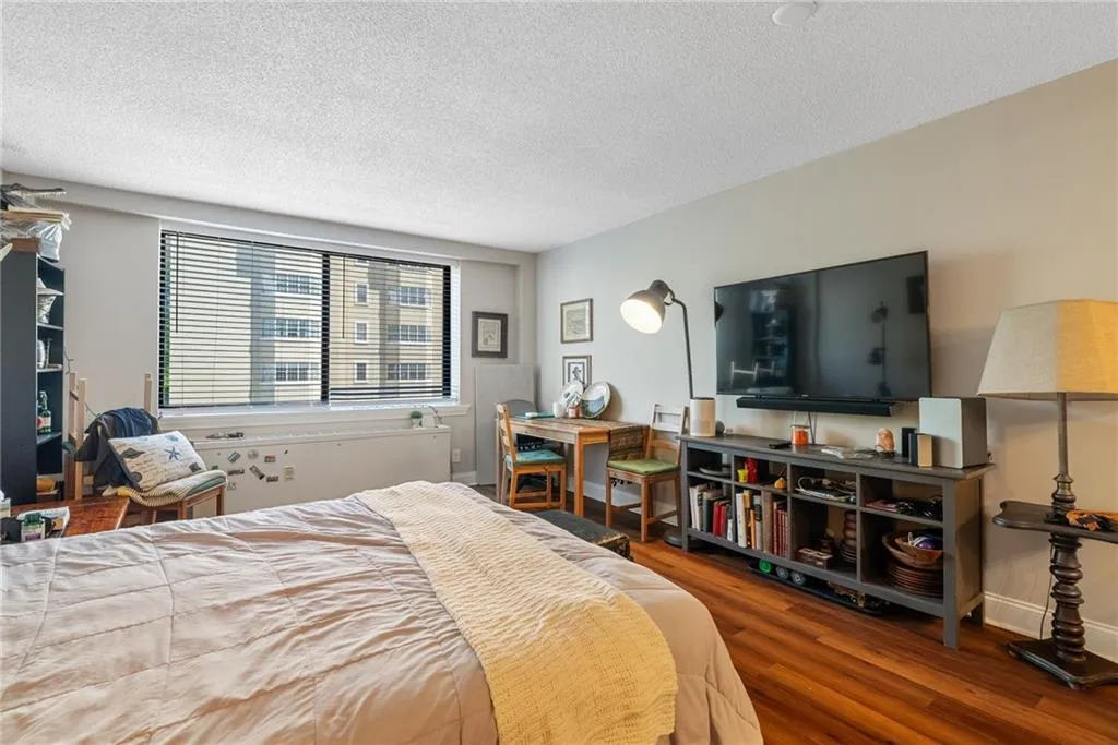 Bedroom with a textured ceiling and hardwood / wood-style floors