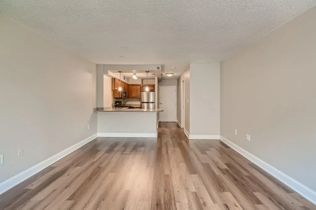 Unfurnished living room with a textured ceiling and light hardwood / wood-style flooring