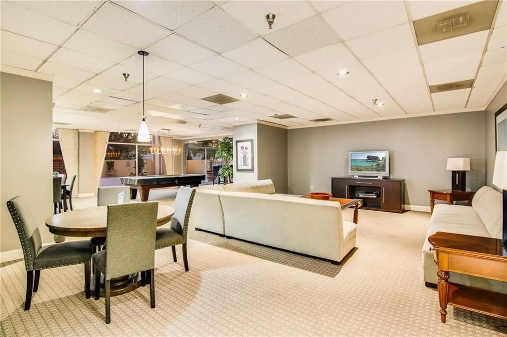Carpeted living room with a paneled ceiling and a chandelier