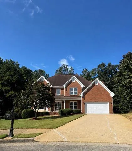 Brick exterior residence featuring a gabled roofline and white trim