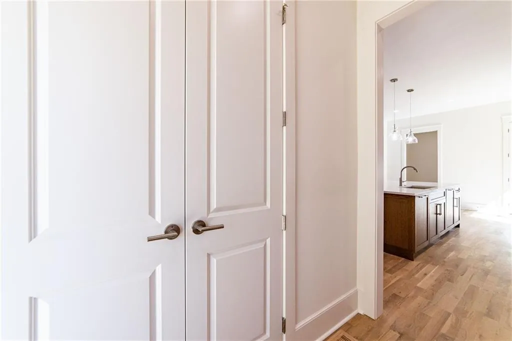 Hallway featuring baseboards, a sink, and light wood-type flooring
