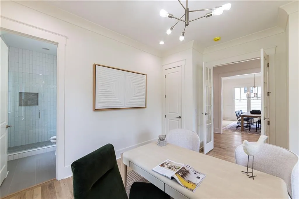 Home office with a chandelier, light wood-type flooring, and baseboards