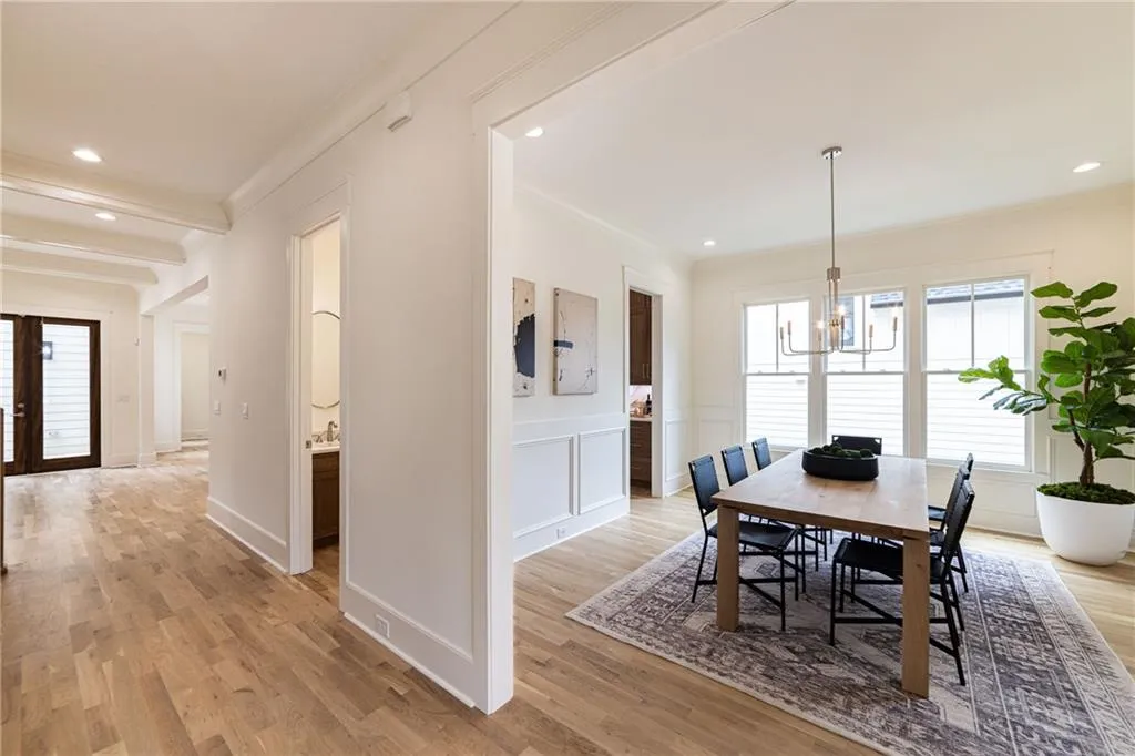 Dining area with crown molding, a chandelier, light wood finished floors, recessed lighting, and electric panel