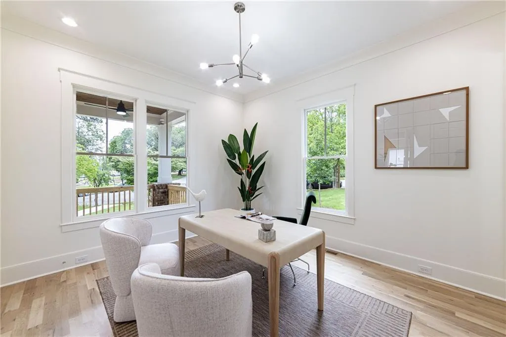 Dining space with light wood-style floors, baseboards, a chandelier, ornamental molding, and an office area
