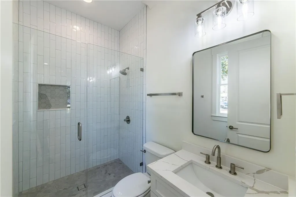 Full bath with a stall shower, toilet, and vanity