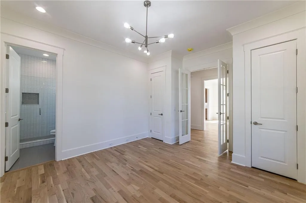 Unfurnished room with ornamental molding, a chandelier, and light wood finished floors