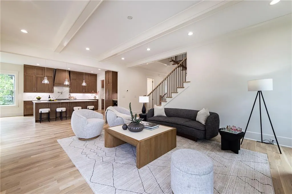 Living room featuring light wood-style flooring, stairway, beam ceiling, recessed lighting, and baseboards