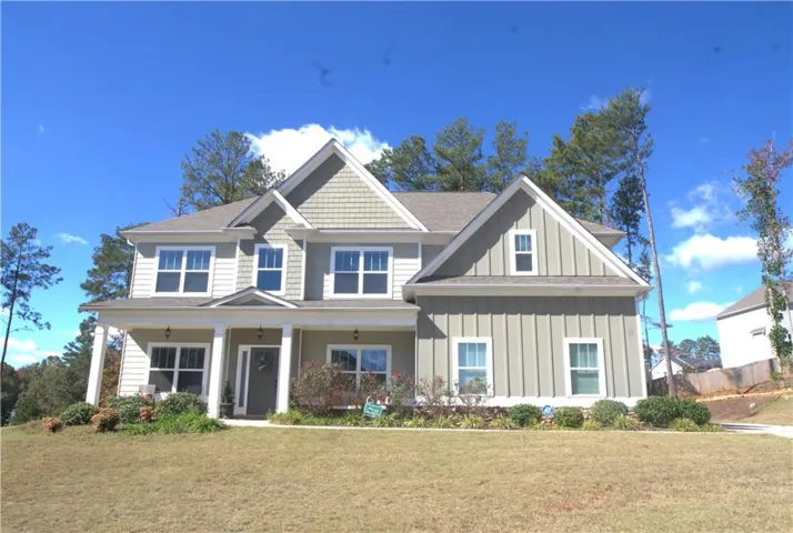 Craftsman-style home featuring board and batten siding, a porch, and a front yard
