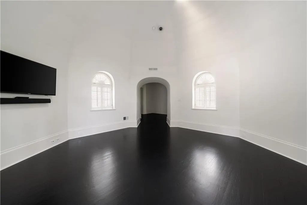 Bonus room with vaulted ceiling, arched walkways, dark wood-style floors, and recessed lighting