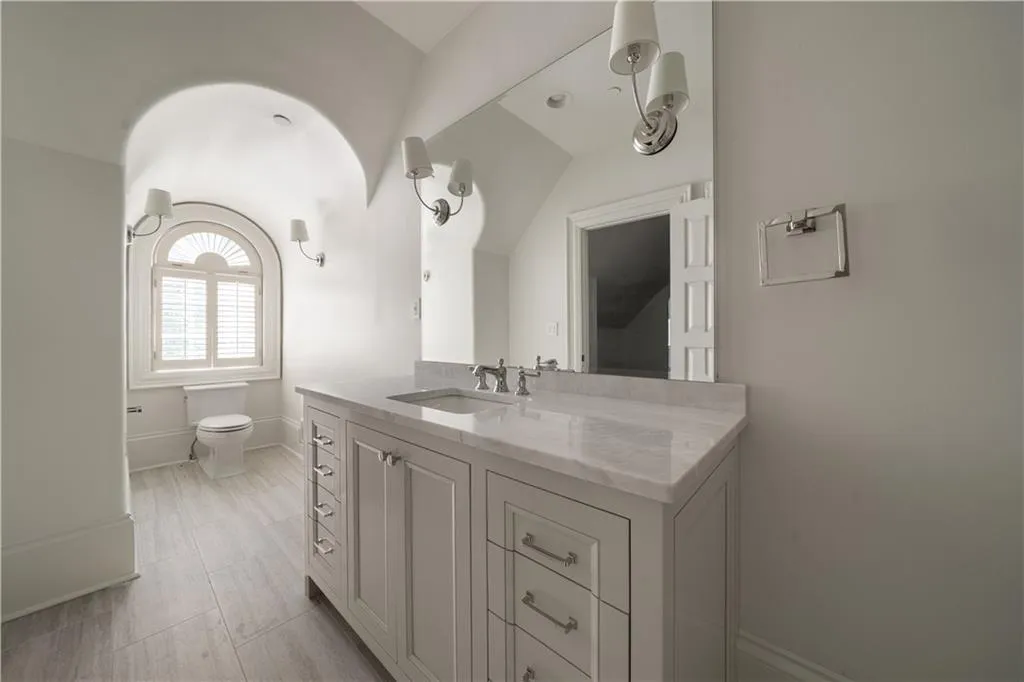 Additional living space featuring dark wood finished floors, vaulted ceiling, and arched walkways