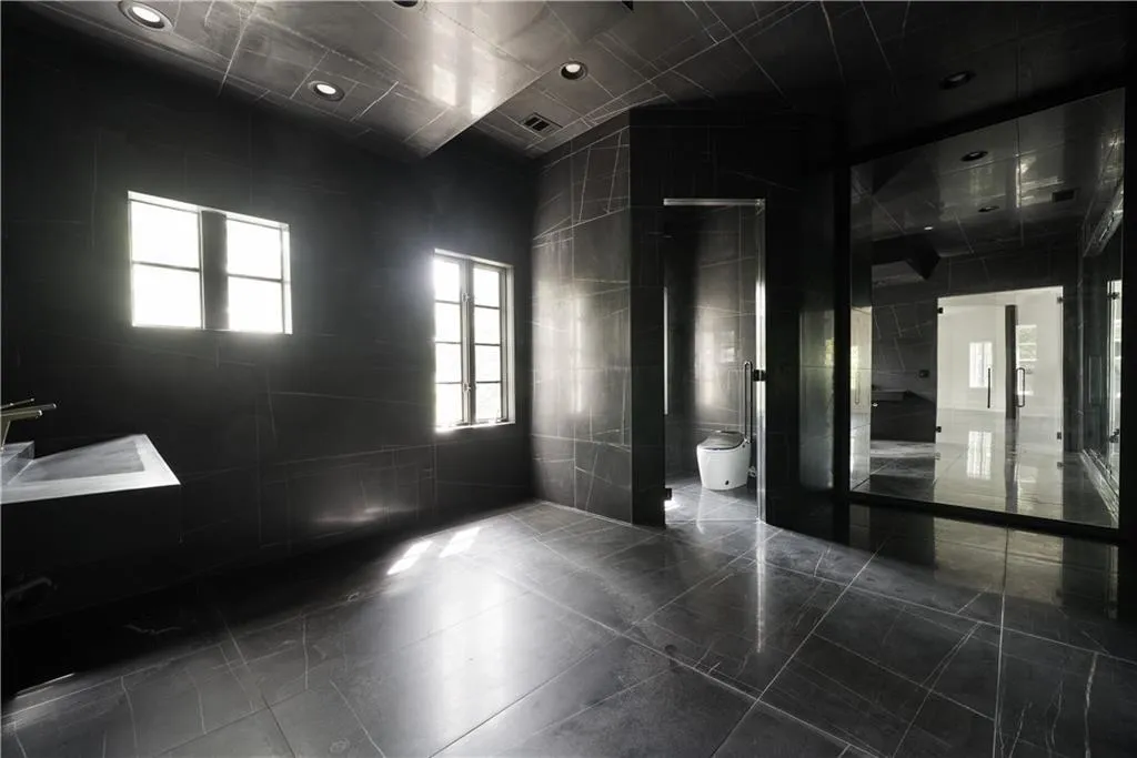 Full bathroom featuring a shower stall, vaulted ceiling, and light tile patterned floors