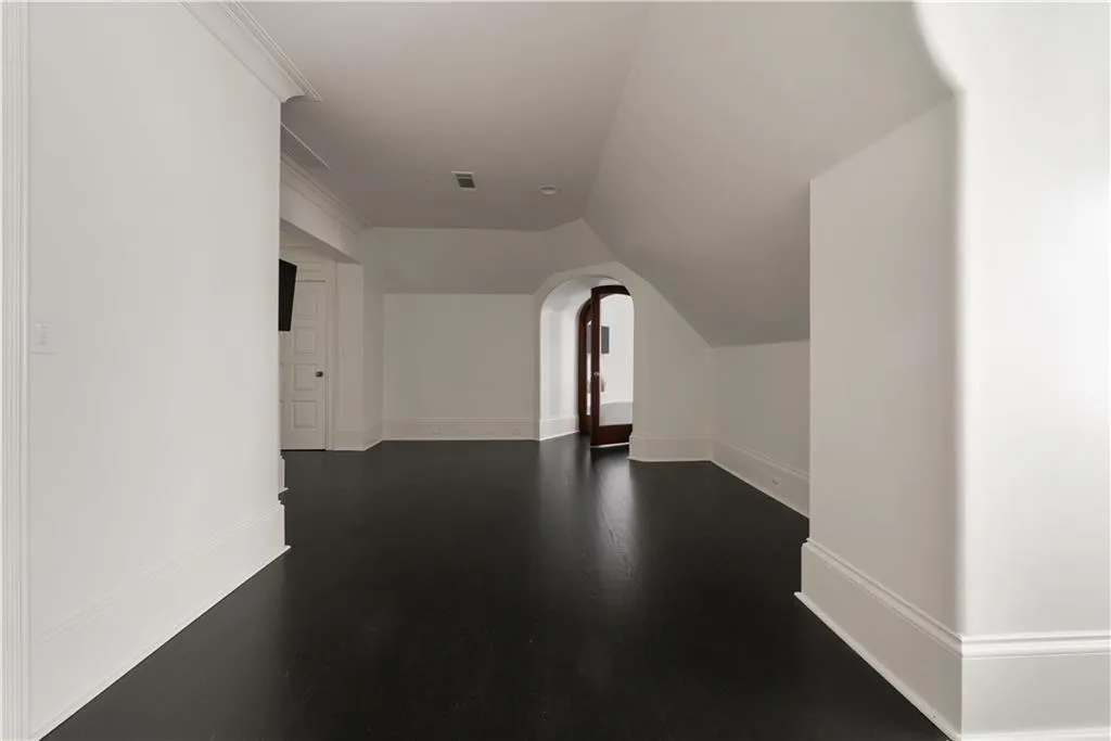 Unfurnished living room featuring wine cooler, crown molding, dark tile patterned floors, a large fireplace, and bar