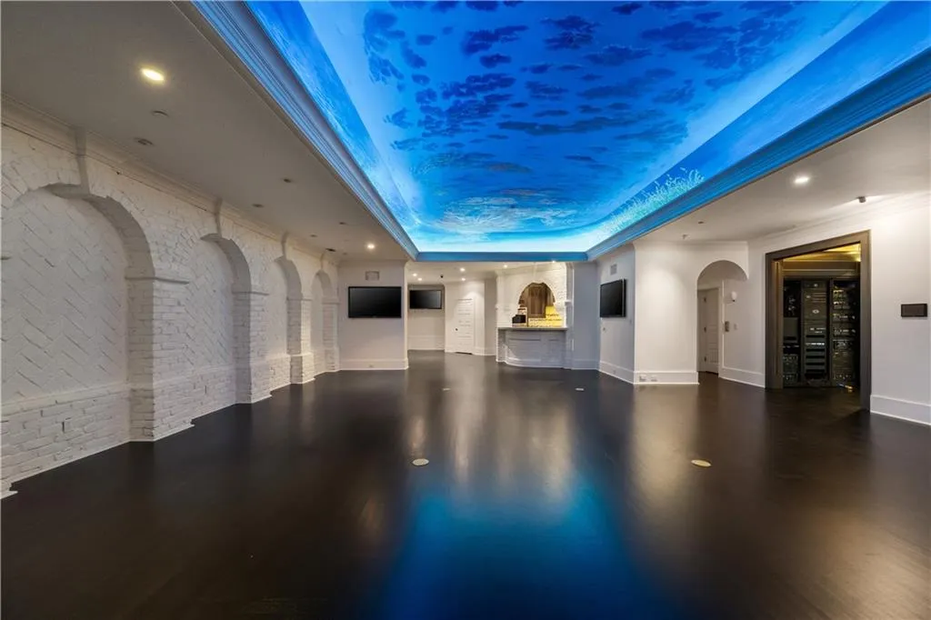 Miscellaneous room with arched walkways, dark wood-style flooring, brick wall, a raised ceiling, and recessed lighting