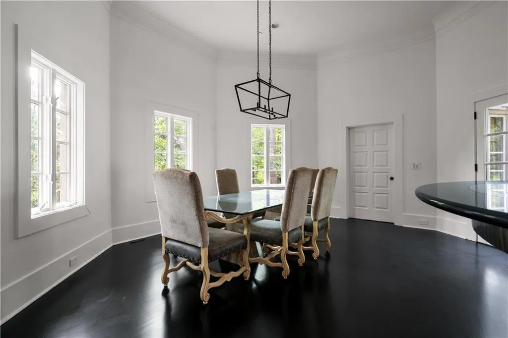Dining room featuring ornamental molding, dark wood finished floors, and a towering ceiling