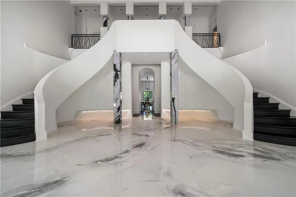 Foyer with stairway, arched walkways, marble tiled flooring, and a towering ceiling