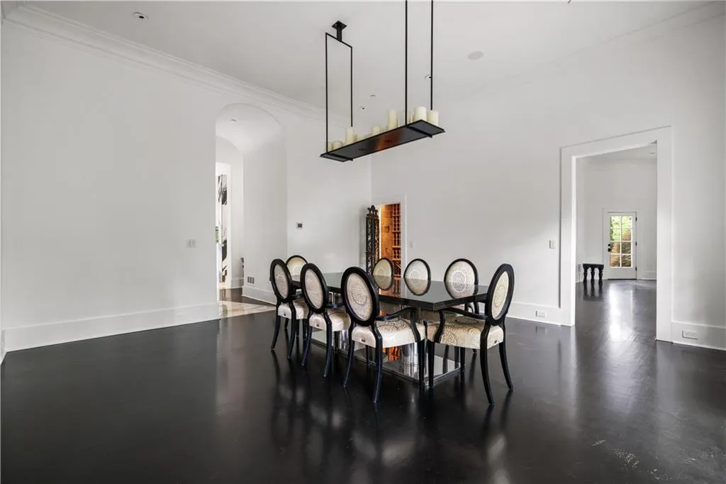 Dining space with crown molding, dark wood-style flooring, and arched walkways