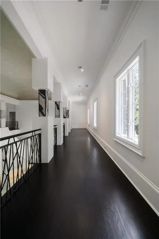 Unfurnished living room featuring wood finished floors, arched walkways, and a high ceiling