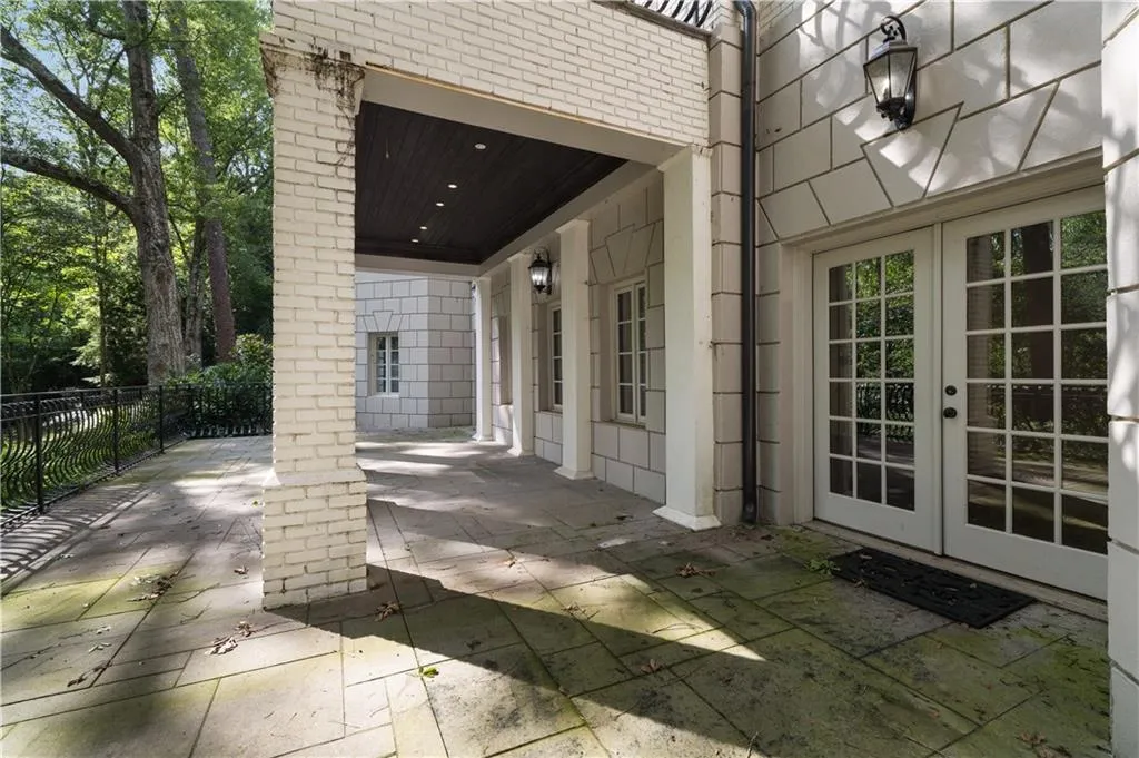Rear view of property with brick siding, a chimney, an outdoor pool, and a high end roof