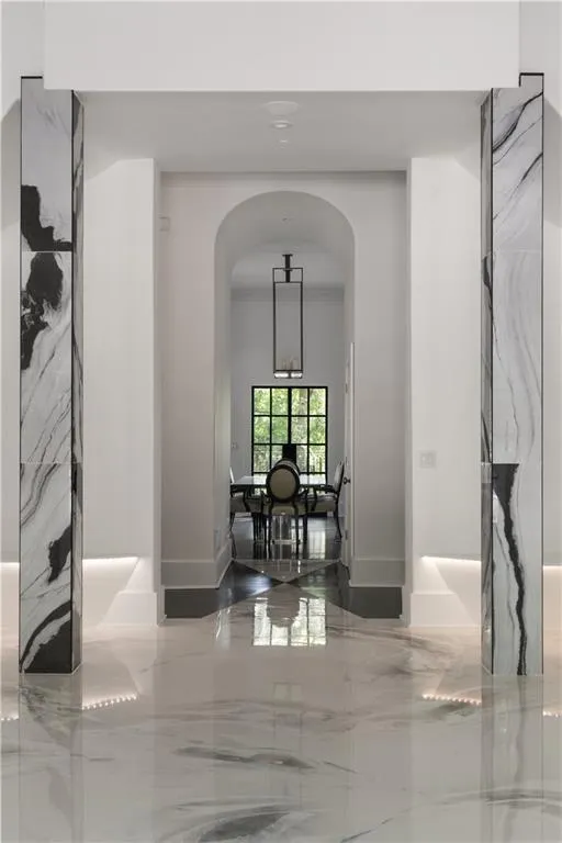 Hallway featuring marble tiled flooring and arched walkways