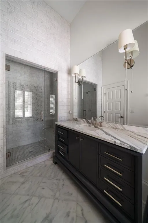 Bathroom with vanity, a stall shower, and light tile patterned flooring