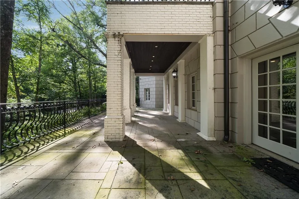 View of front of home featuring a gate, brick siding, and a chimney