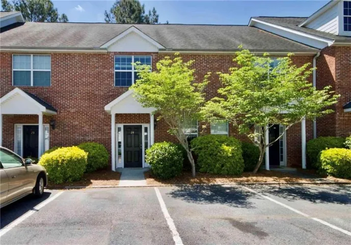 Red brick exterior featuring white gables and entry porticos