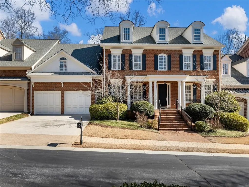 Colonial home featuring covered porch and a garage.
