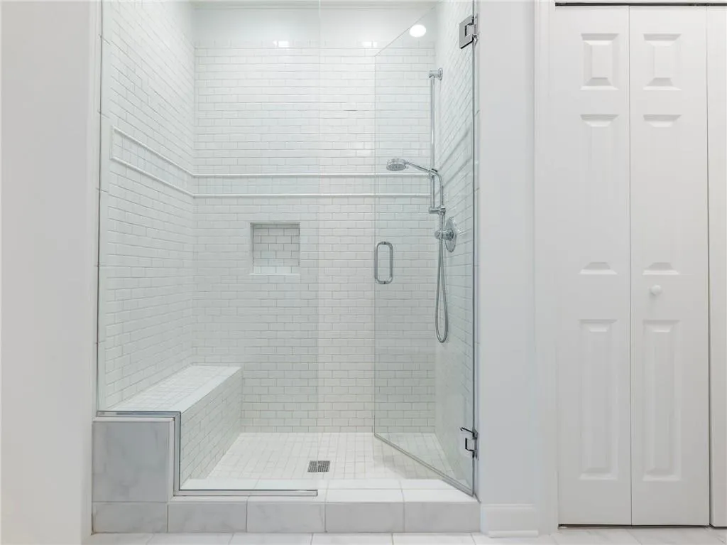 Bathroom featuring a shower with door and tile patterned flooring