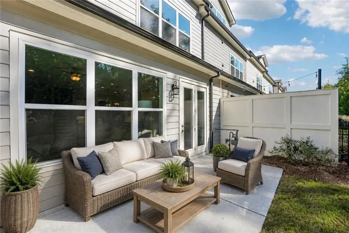Patio with concrete surface, French doors, multiple pane windows, and a privacy fence