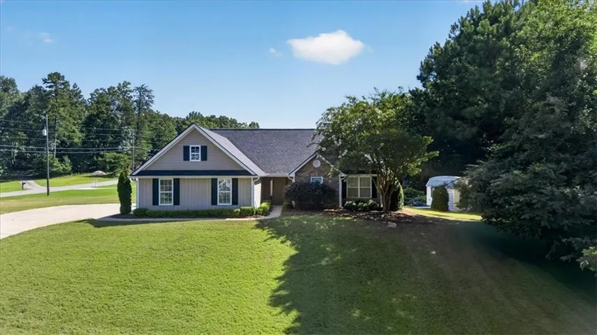 Ranch-style residence featuring a gray shingle roof and light-colored siding