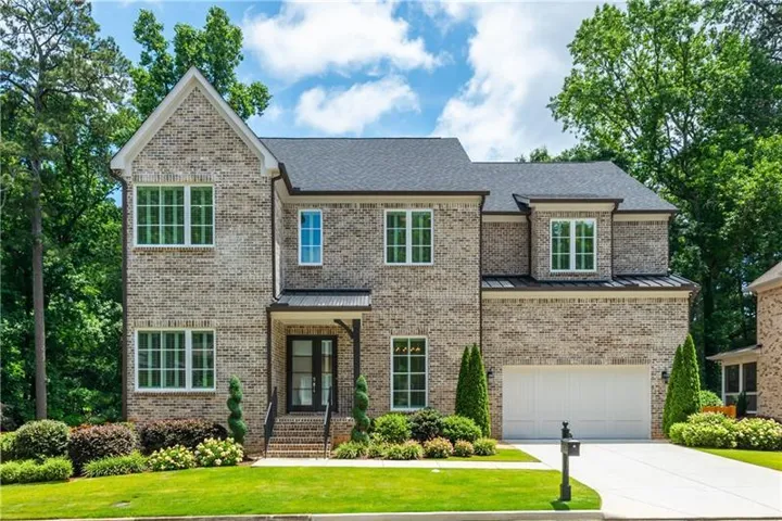 Brick exterior with dark shingle roof and white-framed windows
