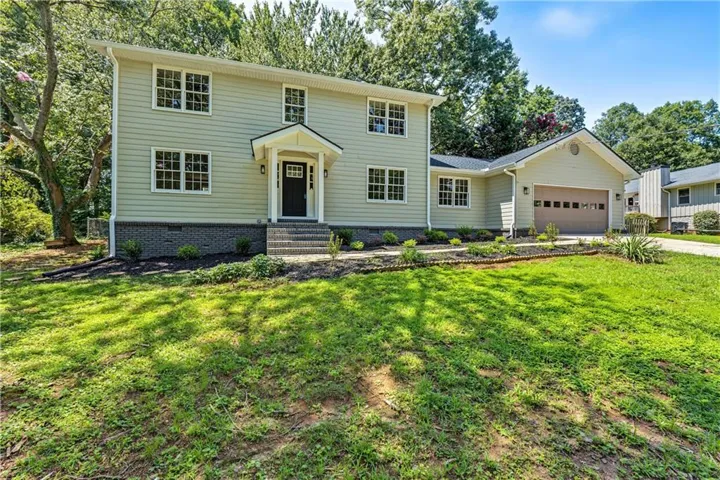 Two-story home with light-colored siding and a dark front door