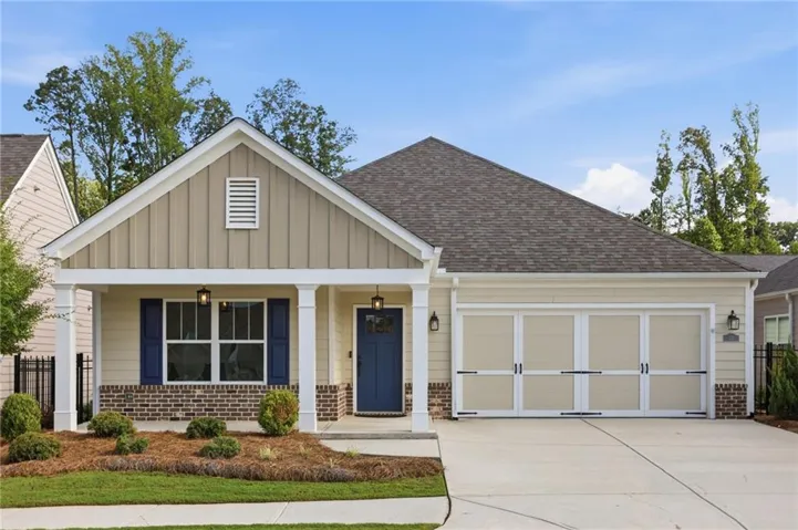 Single-story residence featuring a covered front porch, a two-car garage, and a concrete driveway