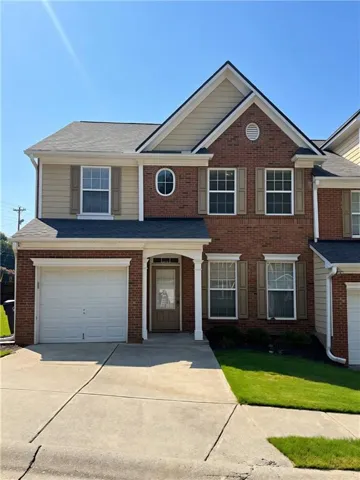 Brick and siding exterior featuring an attached garage, covered entryway, double-hung windows with shutters, and an oval window accent