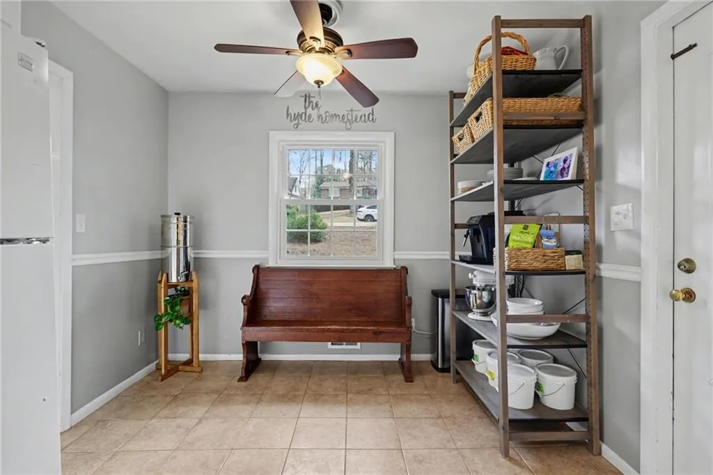 Living area with a ceiling fan and light tile patterned floors