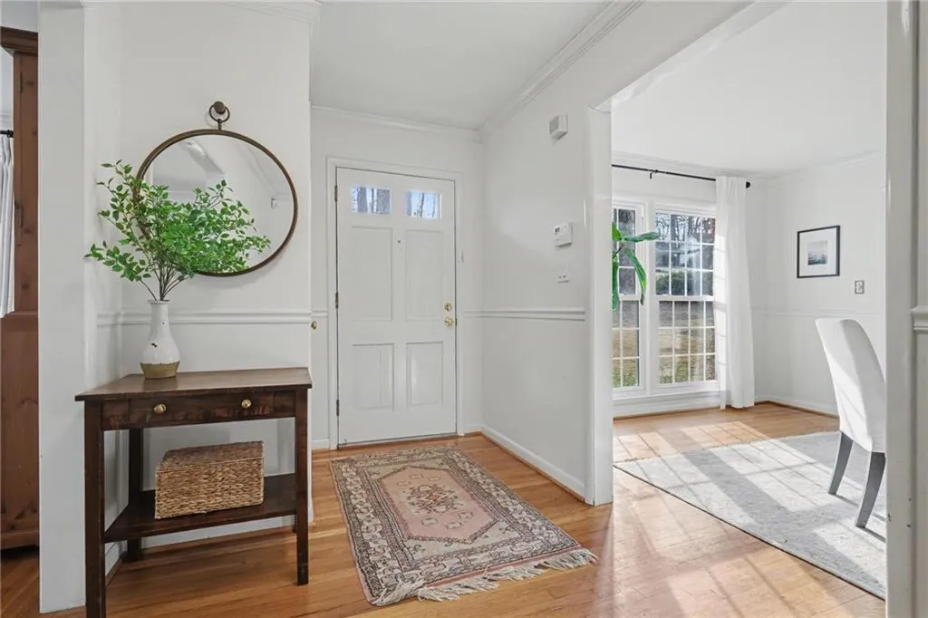 Foyer entrance featuring crown molding and light wood finished floors