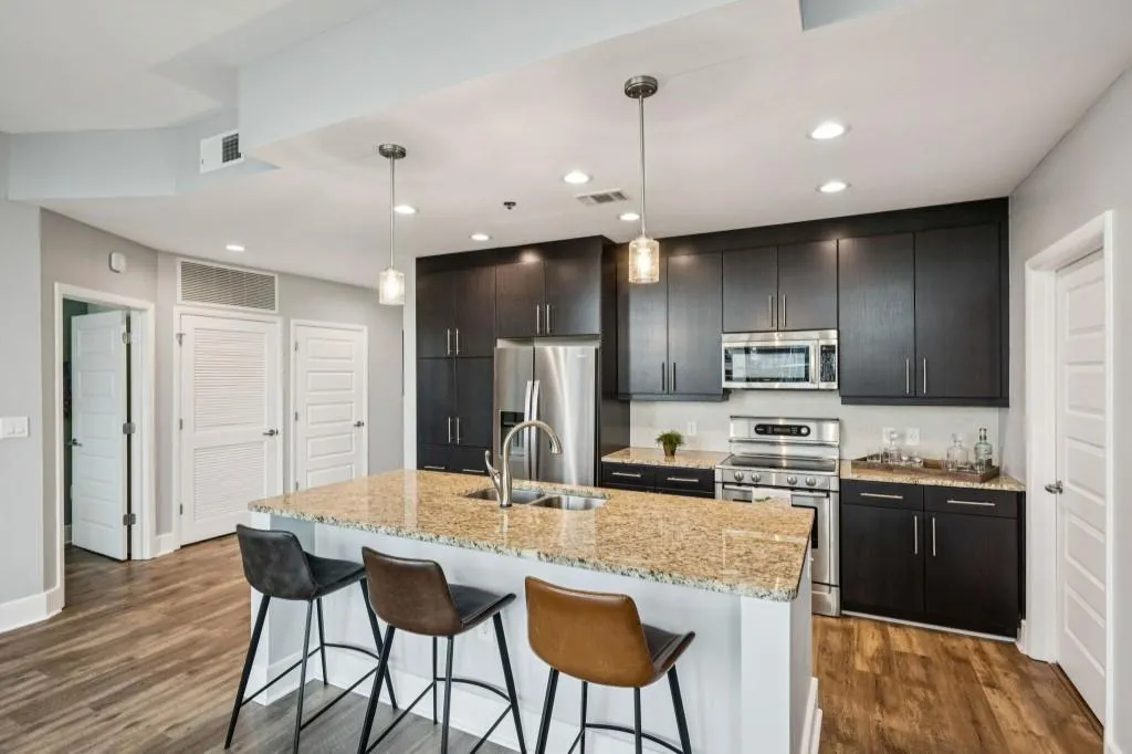 Step inside to find an Open-Concept Layout featuring a Chef's Kitchen with Granite Countertops, Stainless Steel Appliances, and Rich Cabinetry flowing seamlessly into the Light-Filled Living Room.
